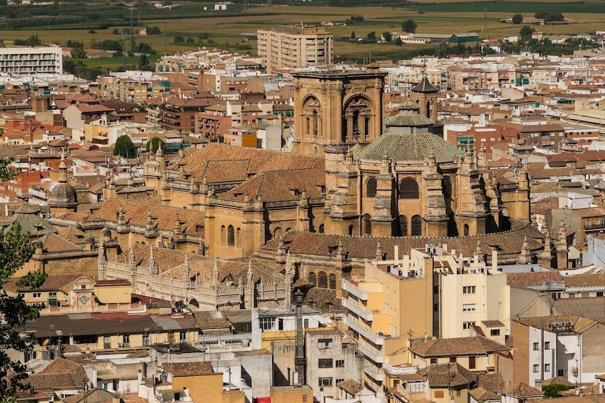 A densely packed urban area with historic architecture, including a prominent church with a dome and bell tower. 1