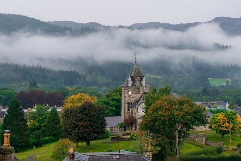 A historic church surrounded by lush greenery and mist-covered hills. 2