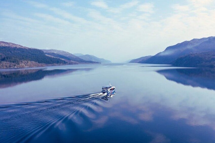 A boat on a calm lake with mountains in the background. 3