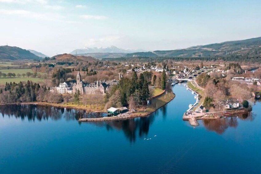 A lake surrounded by a town with a castle, a church, and a river. 5