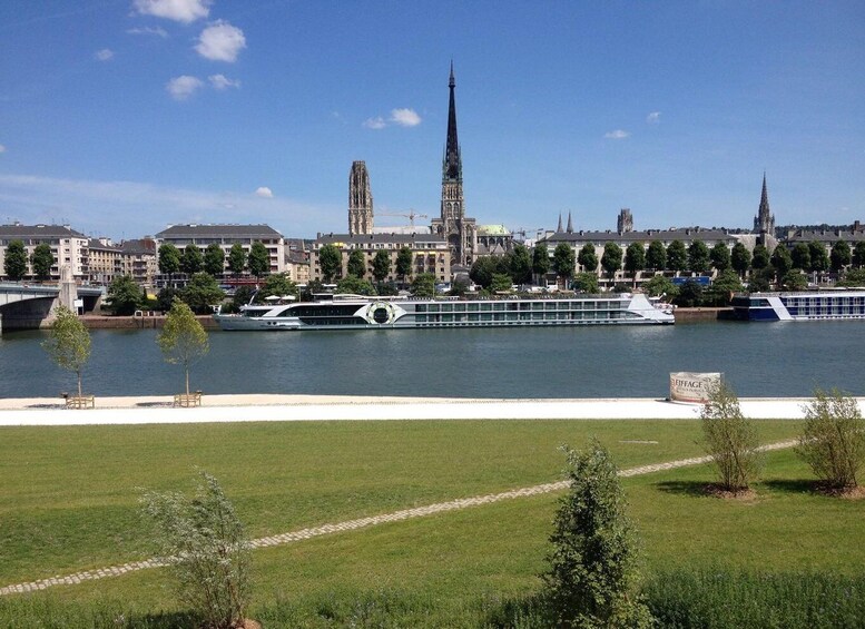 A river with a cruise ship, a bridge, and historic buildings including a tall spire. 2