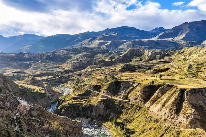 A mountainous landscape with terraced fields and a river. 3