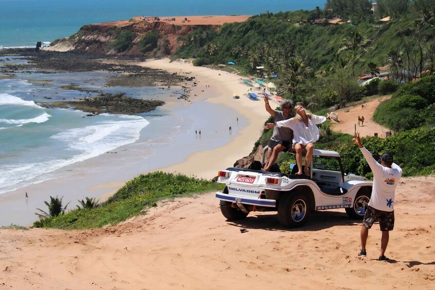 A beach with people on a vehicle, a sandy shore, and ocean waves. 5