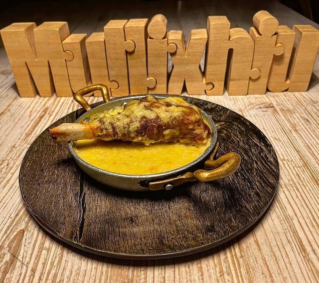 A dish of chicken in a pan with a golden crust, served on a wooden plate. 5