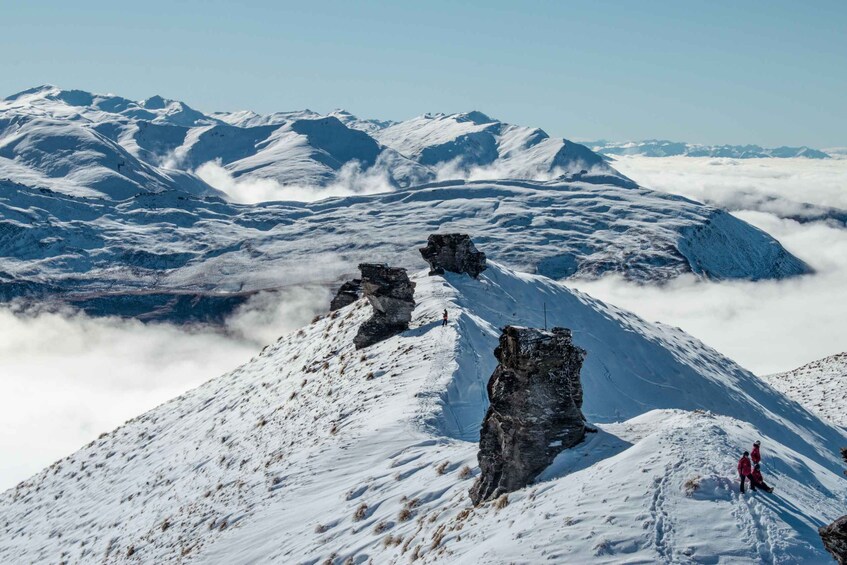 A snow-covered mountain peak with rocky outcrops and a clear sky. 3