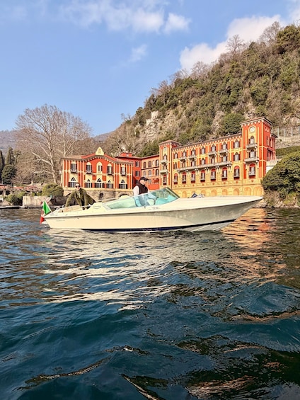 A boat on water with a red building in the background. 1