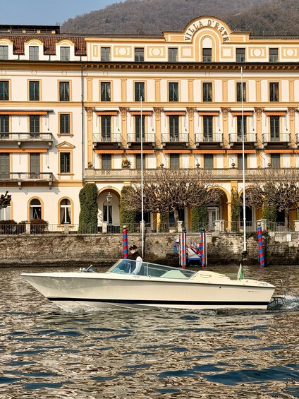 A waterfront building with balconies and a boat in the foreground. 2