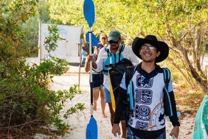 A person walking on a sandy path with trees and a blue paddle in the background. 1