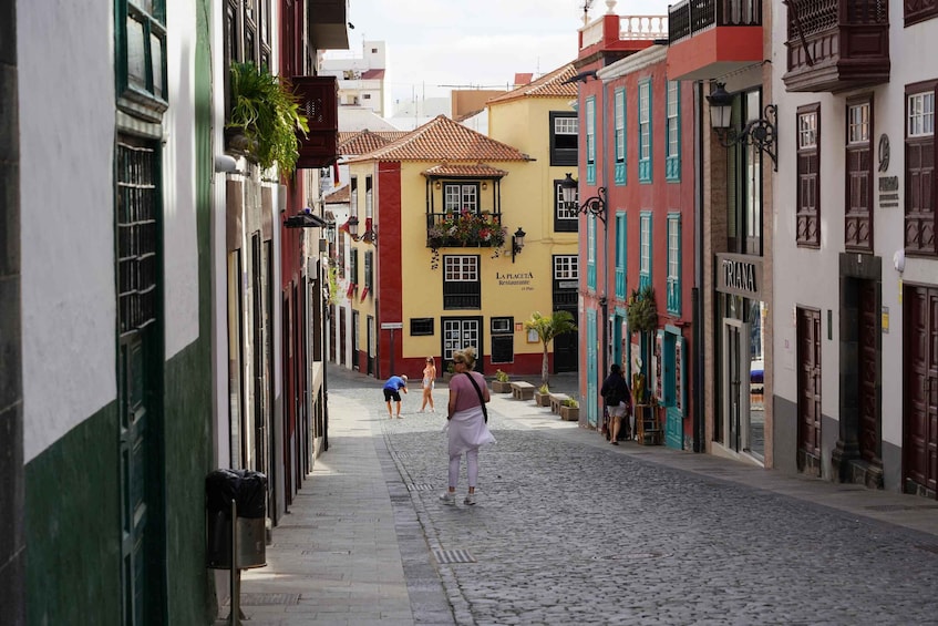 A cobblestone street lined with colorful buildings, including a shop named 'LA PLACETA.' 1