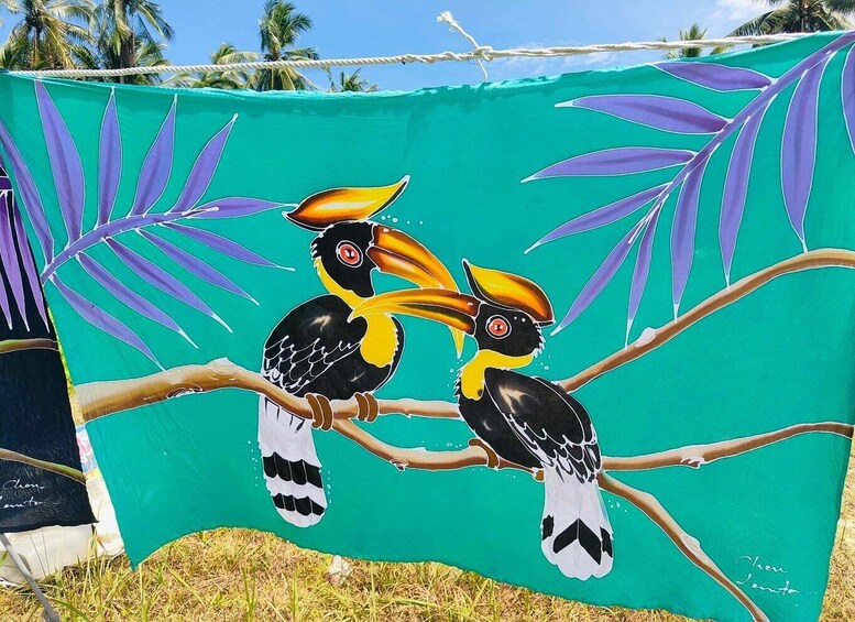A tapestry with toucans on a branch against a green background. 2