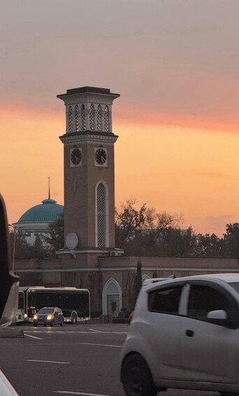 A tower with clocks, a dome, and a sunset sky. 5