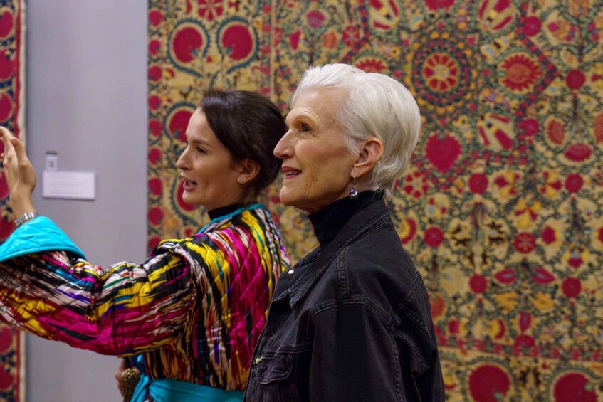 Two people taking a selfie in front of a patterned wall. 4