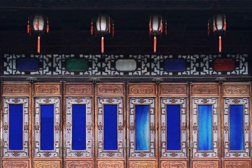A traditional building with ornate wooden doors and blue-tinted windows. 4