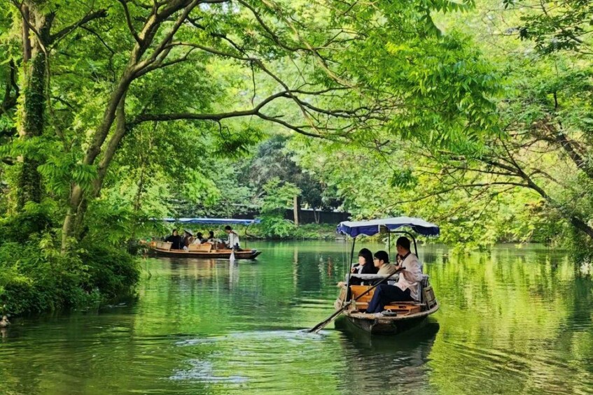 A river with boats and people, surrounded by lush greenery. 1