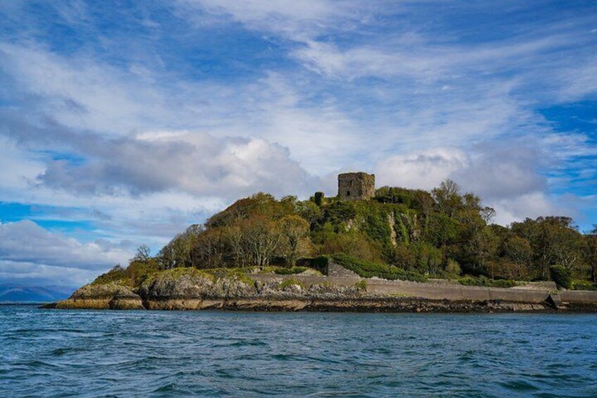 A coastal island with a castle-like structure, surrounded by water and greenery. 3