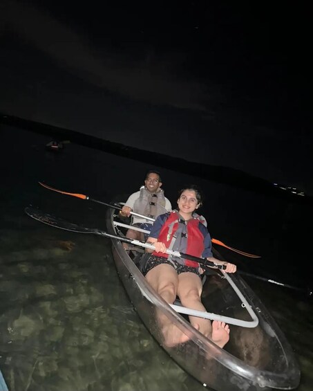 Two people in a small boat on a body of water at night. 3
