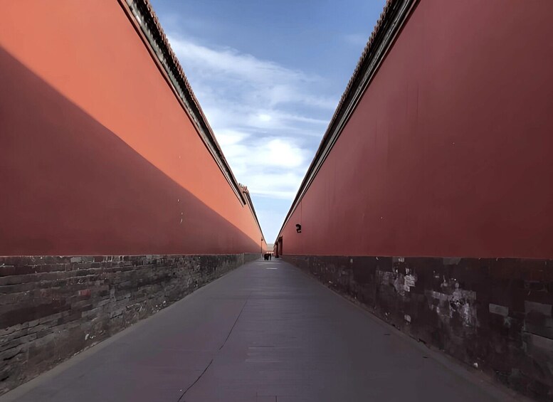 A long, straight pathway flanked by red walls, leading to a distant point. 4