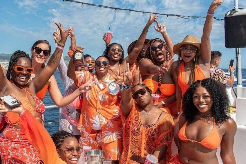 A group of people on a boat, wearing summer attire, with a clear sky and calm sea in the background. 3