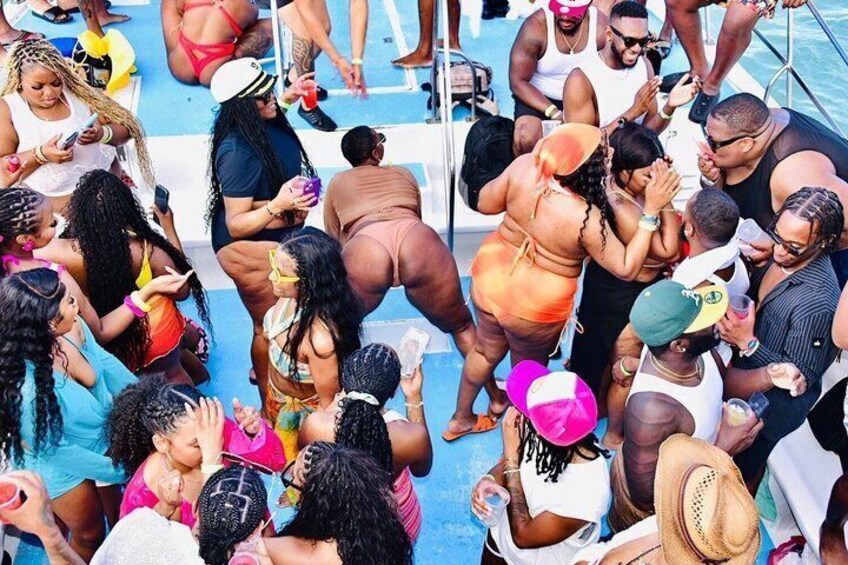 A group of people gathered around a pool, some holding drinks and engaging in conversation. 1