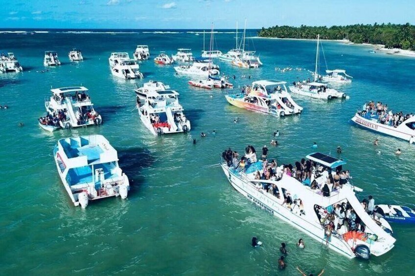 A marina with multiple boats docked, surrounded by clear blue water and a distant shoreline. 5
