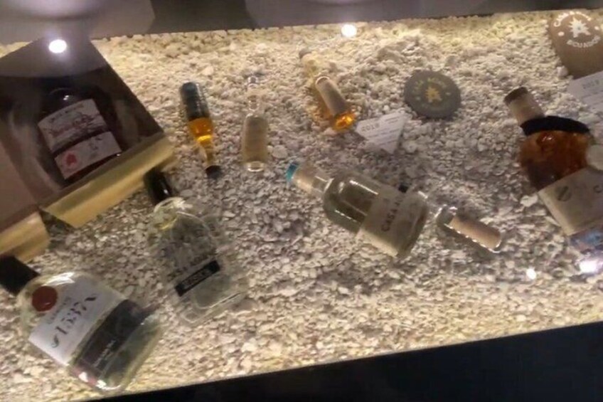 A display of various bottles on a textured surface. 5