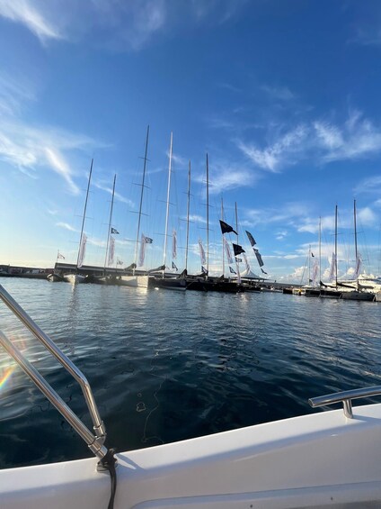A marina with multiple sailboats docked, calm water, and a clear blue sky. 3
