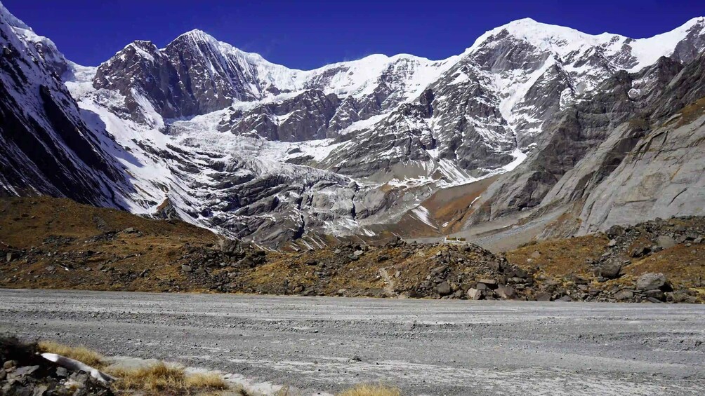 A rugged mountain landscape with snow-capped peaks and a clear sky. 2