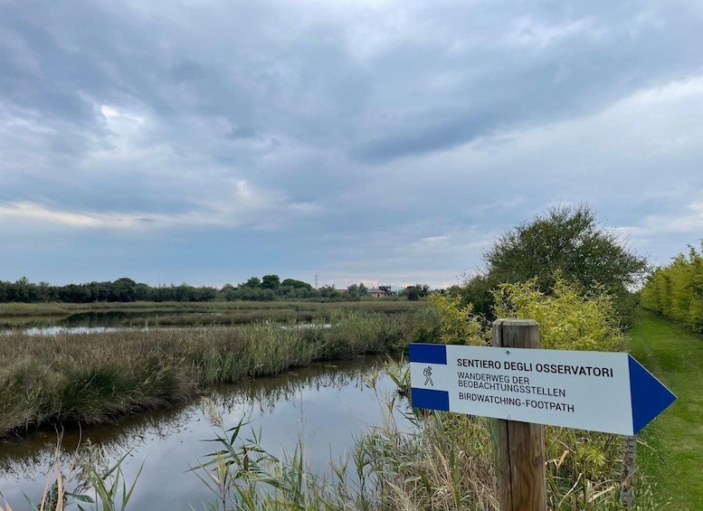 A signpost with directions to Sentiero Degli Osservatori, a walking trail, and birdwatching path. 3