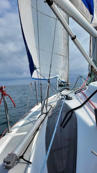 A sailboat's rigging and sails against a cloudy sky. 3
