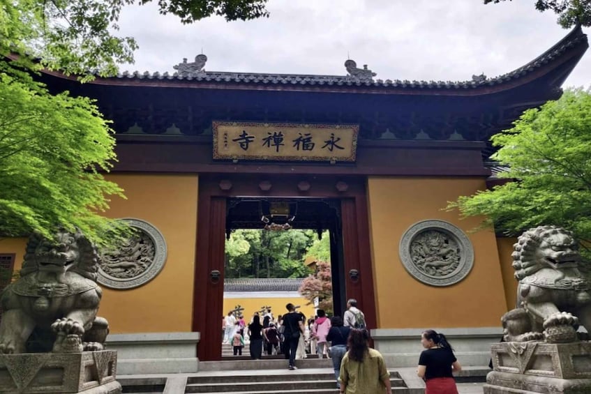 A traditional gate with a sign, flanked by stone lion statues, leading into a courtyard. 3