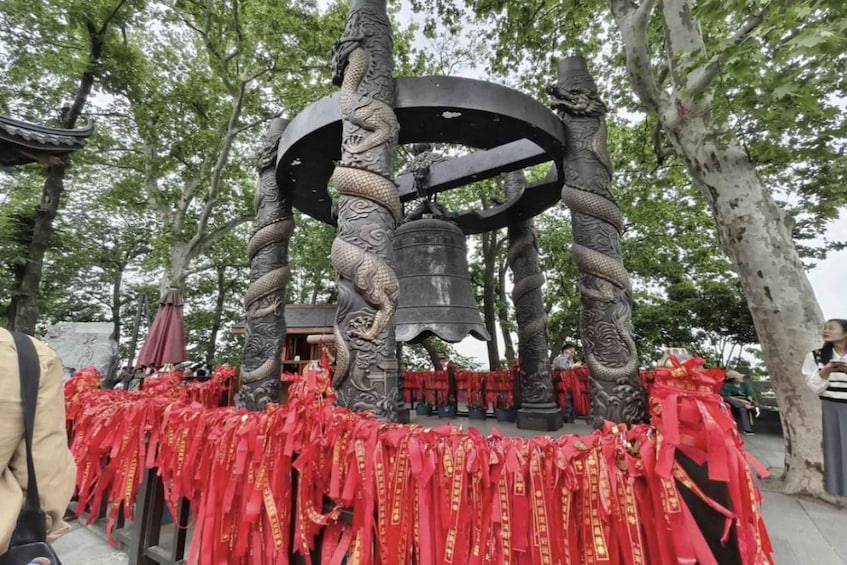 A traditional Chinese bell tower with dragons, surrounded by red ribbons. 4