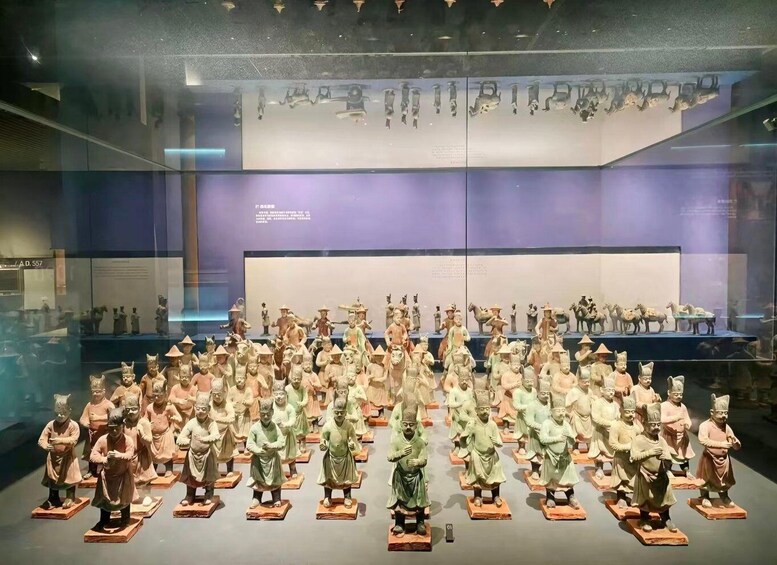 A museum display of terracotta soldiers arranged in rows. 3