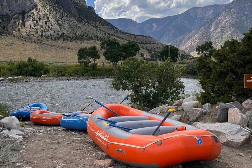 Inflatable rafts by a river with mountains in the background. 3