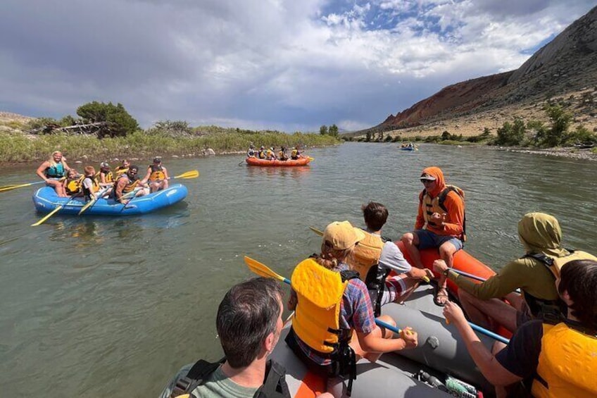 People rafting on a river with mountains in the background. 4
