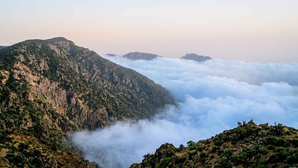 A mountainous landscape with a valley shrouded in clouds. 4
