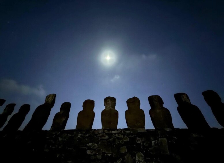A row of Moai statues under a night sky with a bright moon. 1