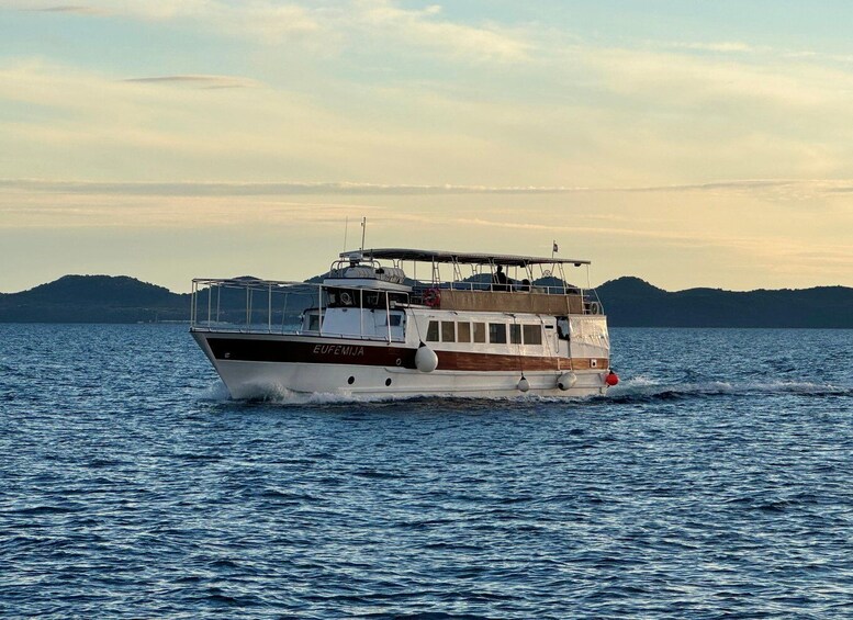 A boat named EUFEMIJIA on the water with mountains in the background. 2