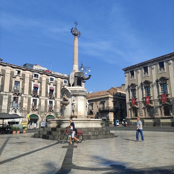 A plaza with a central monument featuring an elephant statue, surrounded by historic buildings. 5