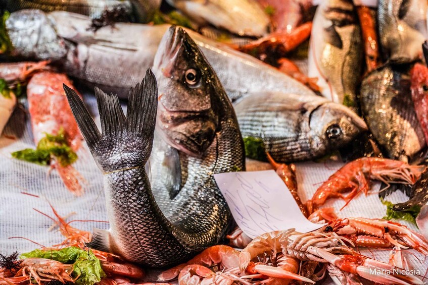 A variety of fresh seafood including fish and shrimp displayed on a table. 3