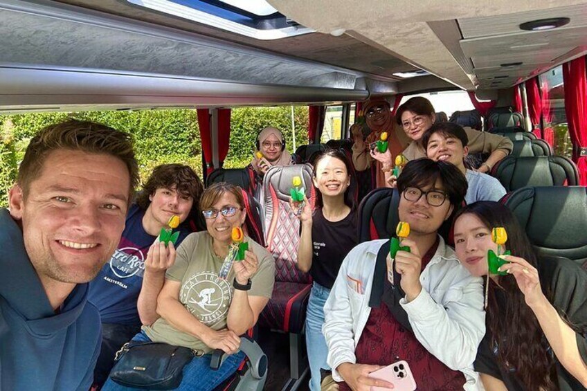 A group of people on a bus with some holding green and yellow objects. 4