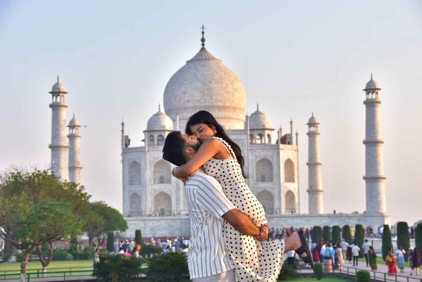A couple embracing in front of the Taj Mahal with the monument's domes and minarets in the background. 3
