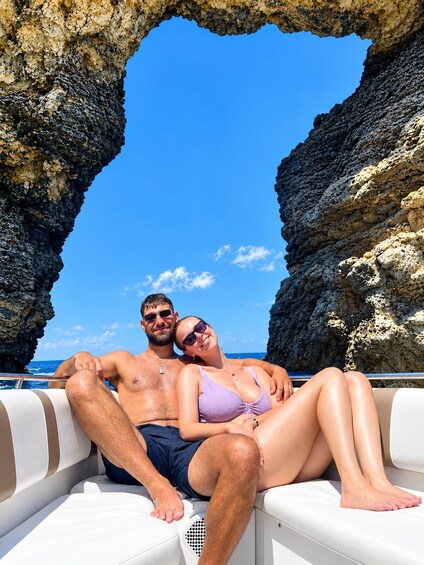 Una coppia su una barca, con un arco roccioso sullo sfondo. 2