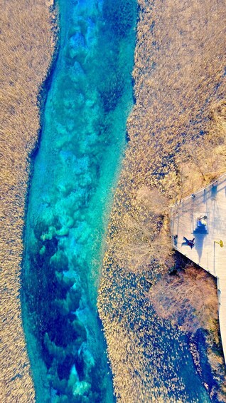 A river with clear turquoise water, surrounded by dry, brown land. 1