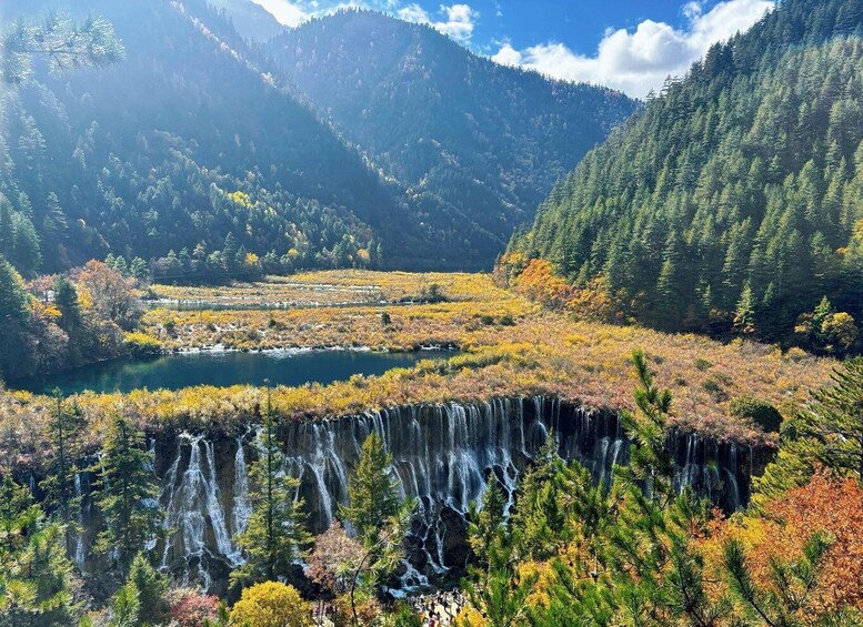 A mountainous landscape with a waterfall, a lake, and autumn-colored trees. 4