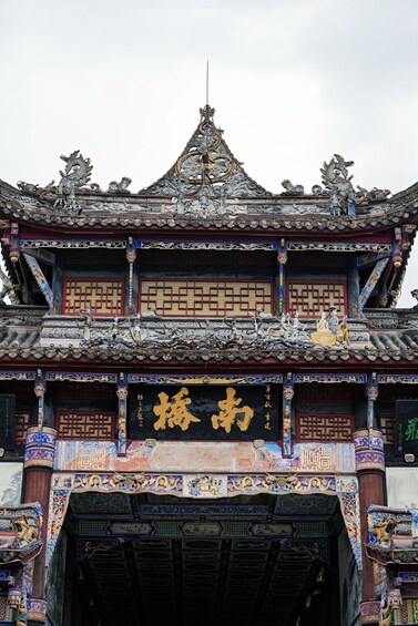 A traditional Chinese building with ornate decorations and a prominent golden inscription. 2