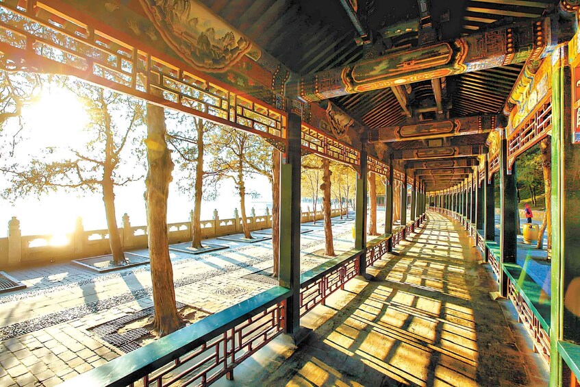 A traditional pavilion with intricate woodwork and a tiled floor, surrounded by trees. 3