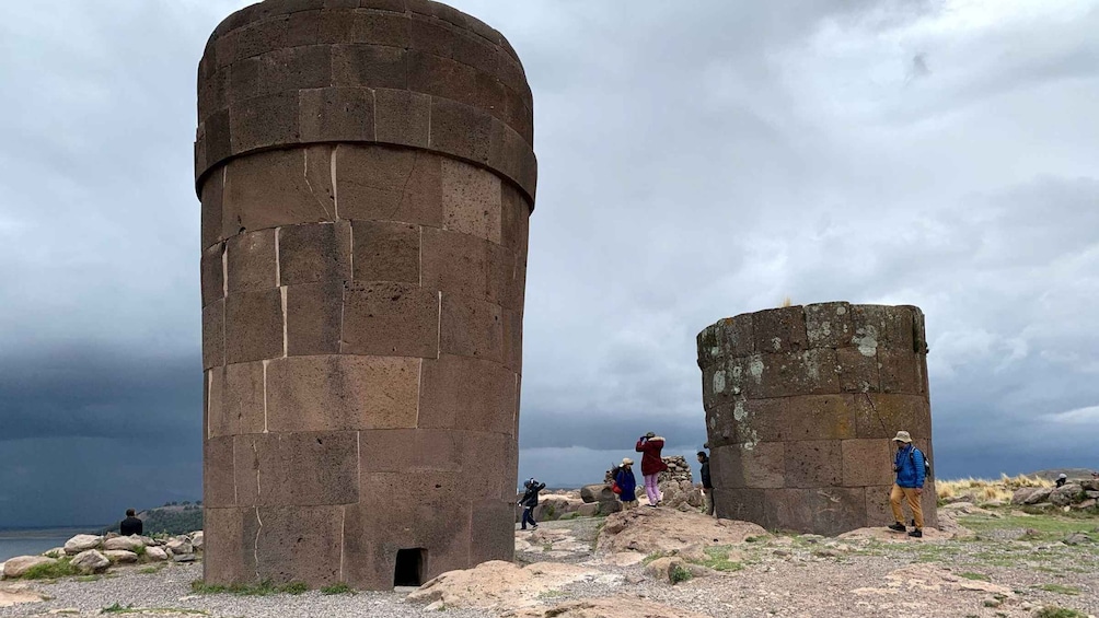 Two large stone towers with people walking around them. 2
