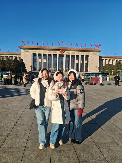 A group of people in front of a large building with columns and red flags. 5
