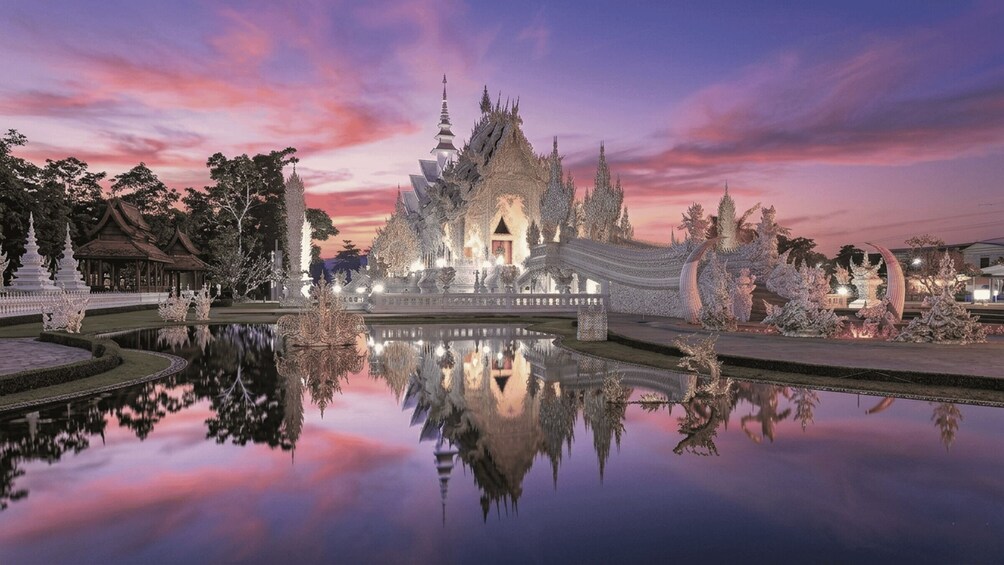 Un ensemble de temples à l’architecture complexe, avec un bassin aux eaux calmes qui reflètent la lumière du crépuscule. 1