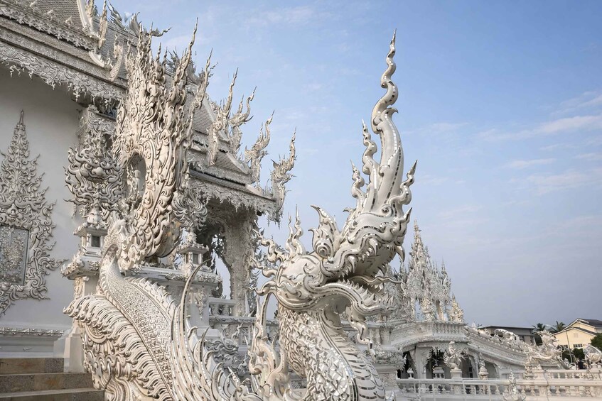 Un temple blanc aux détails raffinés, orné de sculptures de dragons, et un ciel dégagé. 4